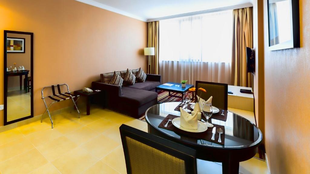 a living room with a couch and a table at Executive Suites Abu Dhabi in Abu Dhabi