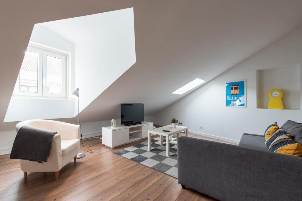 a living room with a couch and a tv at Charming Apartment Tram 28 in Lisbon