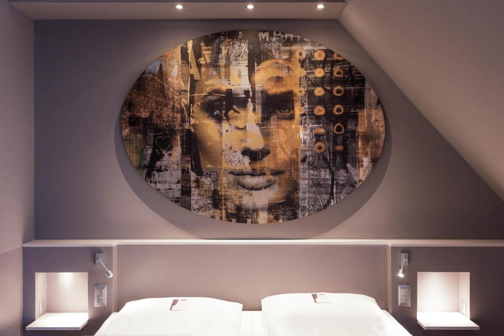 ウィーンにあるデア ウィルヘルムスホフの壁に絵画が飾られた部屋のベッド2台