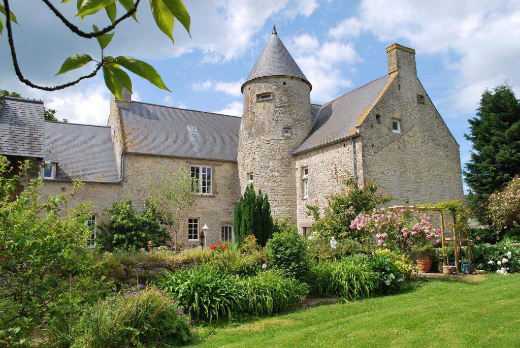 uma antiga casa de pedra com uma torre em Le Manoir De Juganville em Saint-Martin-de-Varreville