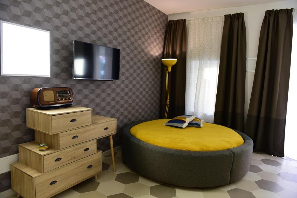a bedroom with a round bed with a tv on the wall at palazzo Clarenza di San Domenico in Catania