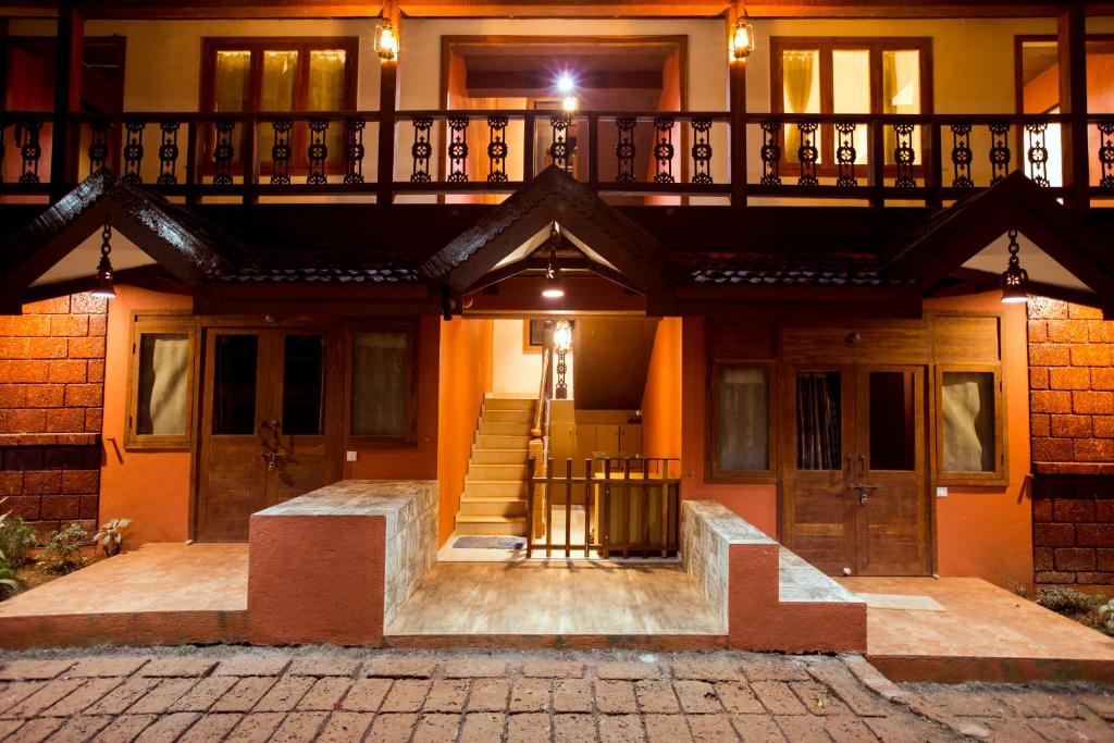 een huis met een balkon er bovenop bij Kaular Atithis Grand Kokan Resort in Ganpatipule