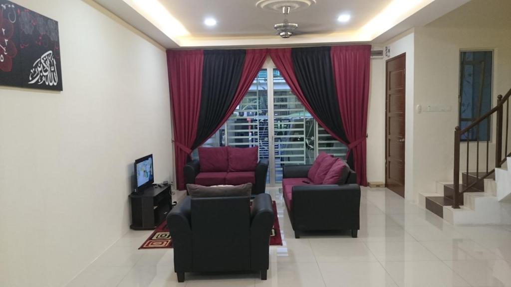 sala de estar con 2 sillas y ventana en Ila Homestay, en Senawang