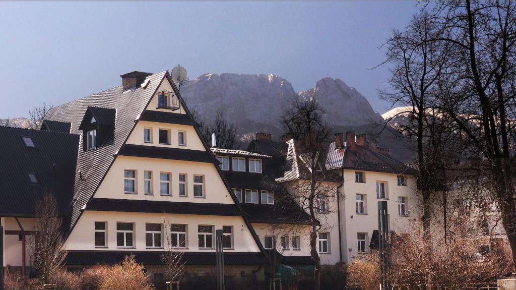 um grupo de edifícios em frente a uma montanha em Pensjonat Adria em Zakopane