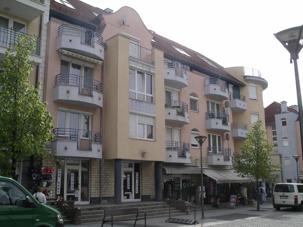 ein großes Gebäude mit Balkonen an einer Stadtstraße in der Unterkunft Centrum 2 Apartmanok in Hévíz
