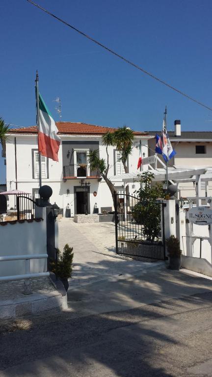 a white building with two flags in front of it at Il Sogno in Tollo