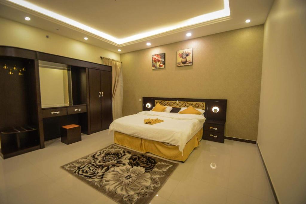 1 dormitorio con 1 cama grande y 1 alfombra en Rekaz Aparthotel, en La Meca