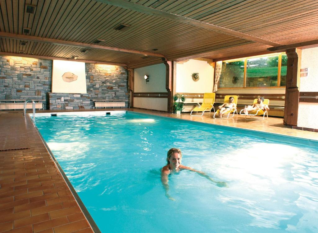 a woman swimming in a swimming pool at Appartementhaus Alpenrose in Wallgau