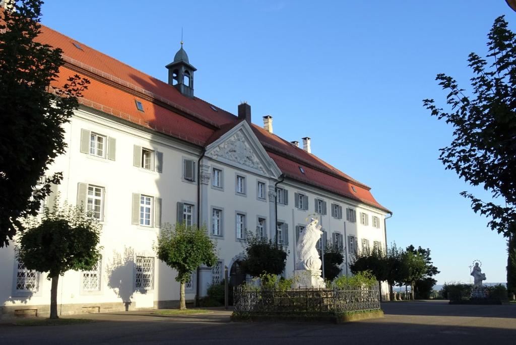 a white building with a statue in front of it at Tagungshaus Schönenberg in Ellwangen