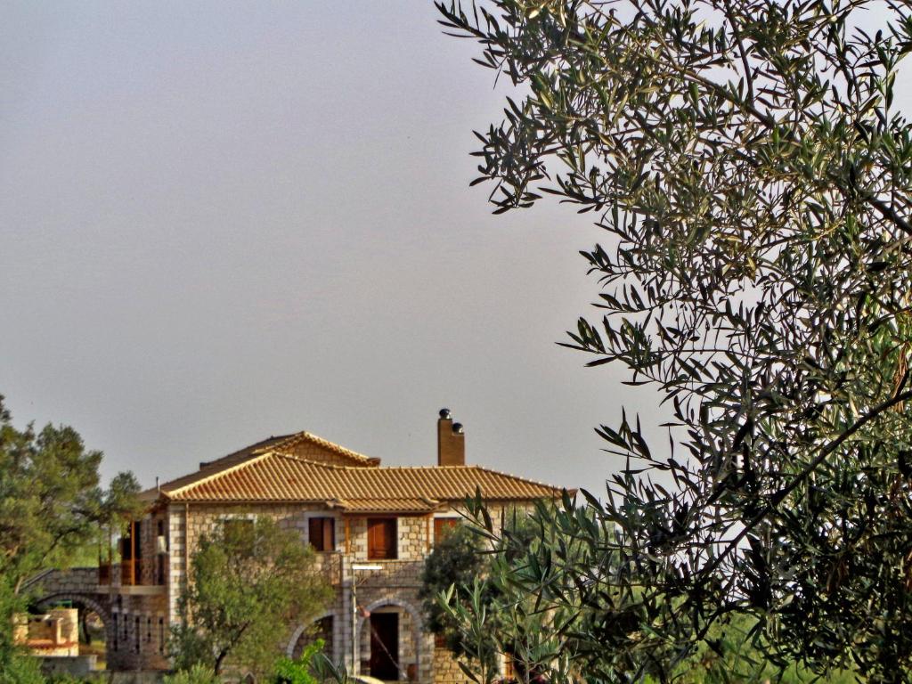 una casa vista a través de un árbol en Menina Farm Kalamata Countryside, en Perivolákia