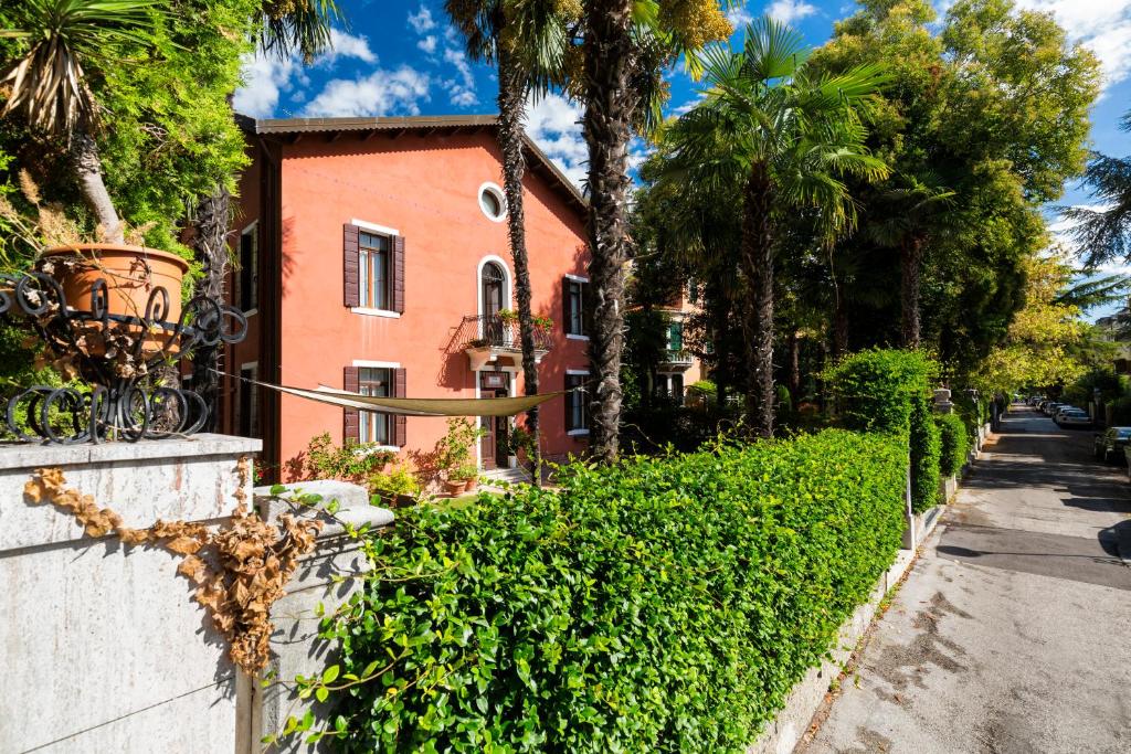 a house with a hedge in front of a street at Villa Casanova in Venice-Lido