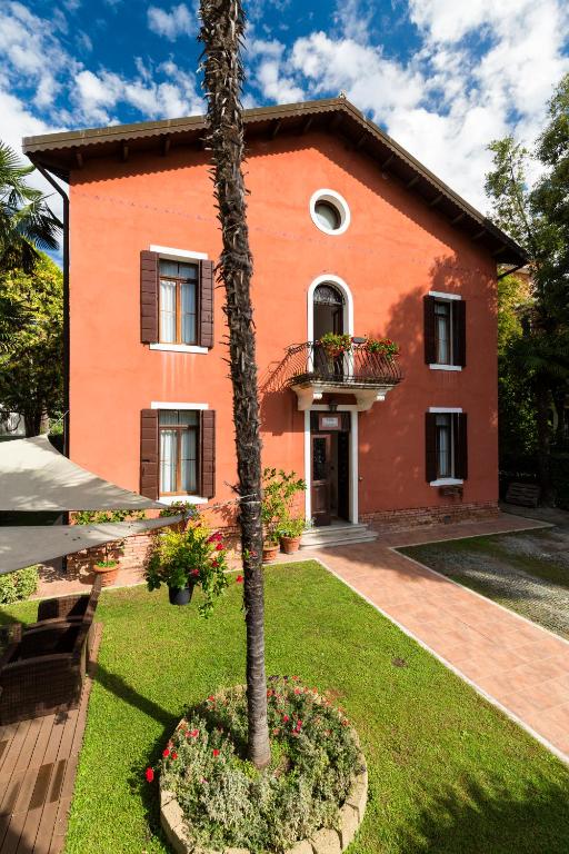 a house with a palm tree in front of it at Villa Casanova in Venice-Lido