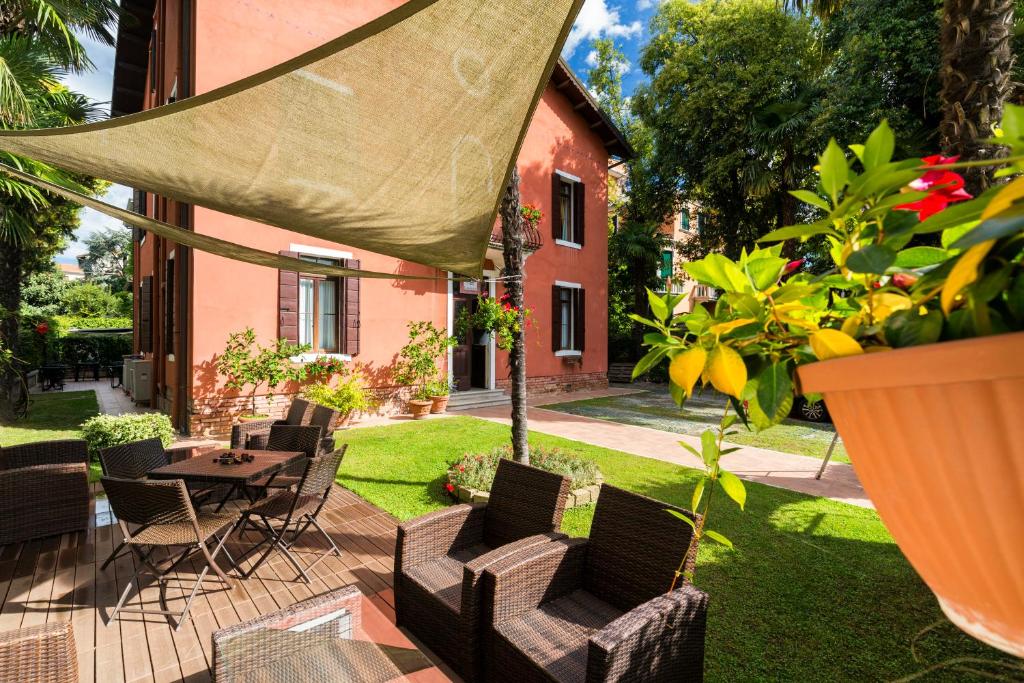 a patio with a table and chairs and a house at Villa Casanova in Venice-Lido