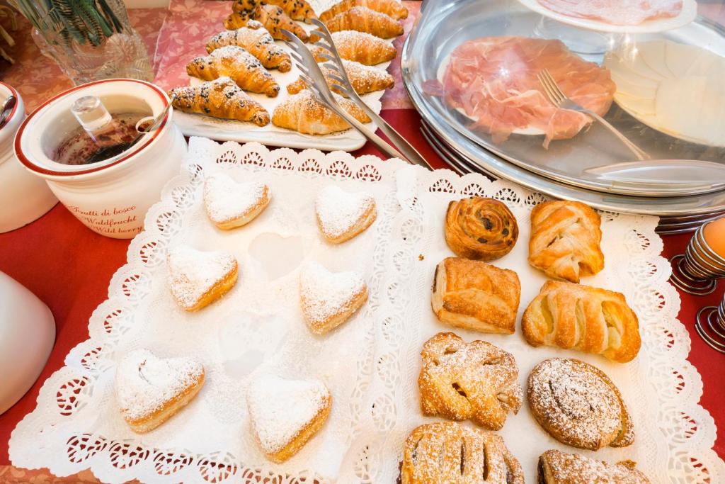 a table topped with bread and pastries on a table at Villa Casanova in Venice-Lido