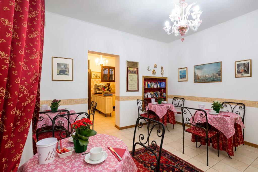 a dining room with tables and chairs with pink tablecloths at Villa Casanova in Venice-Lido