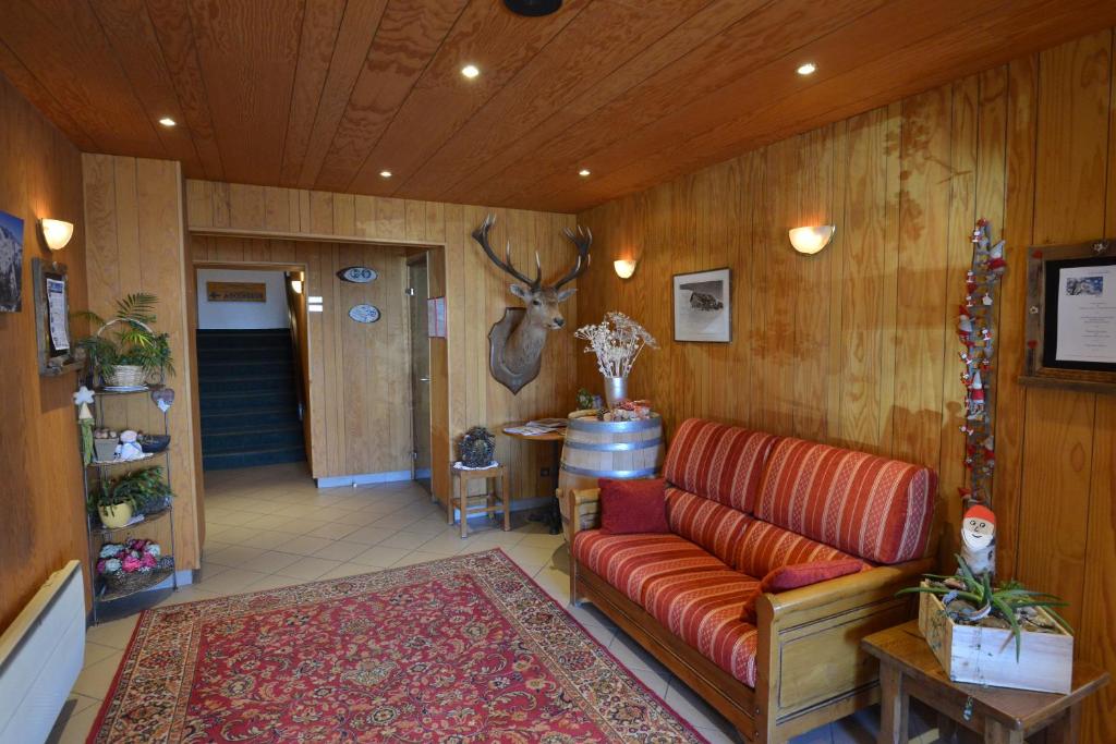 a living room with a couch and a deer head on the wall at Hôtel Le Dôme in L&#39;Alpe-d&#39;Huez