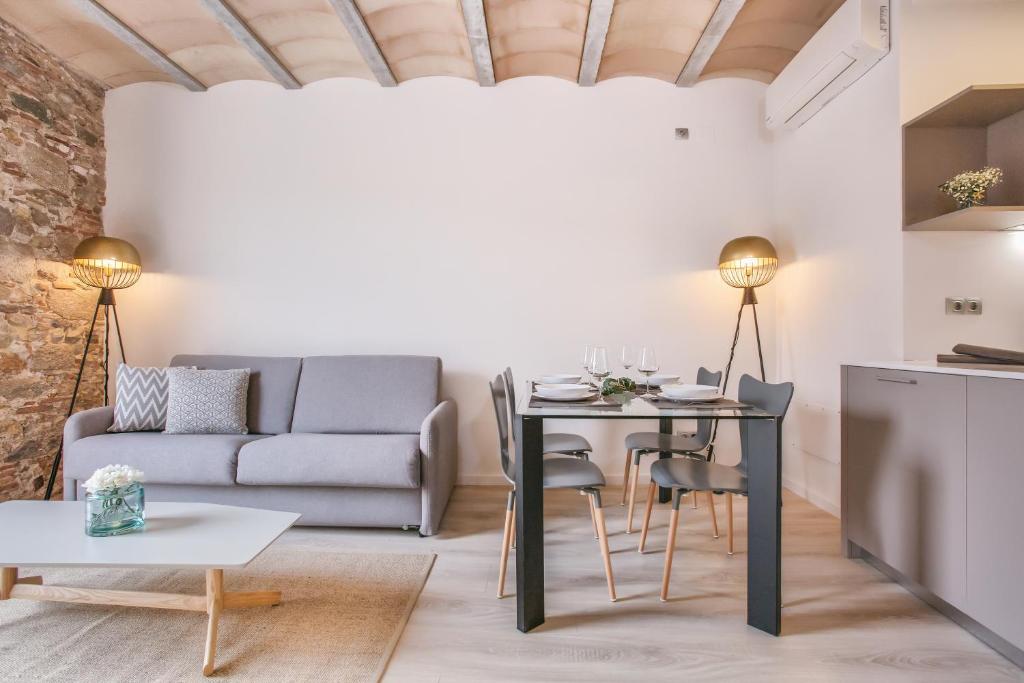 a living room with a table and a couch at Flateli- Plaça Catalunya 2-1 in Girona