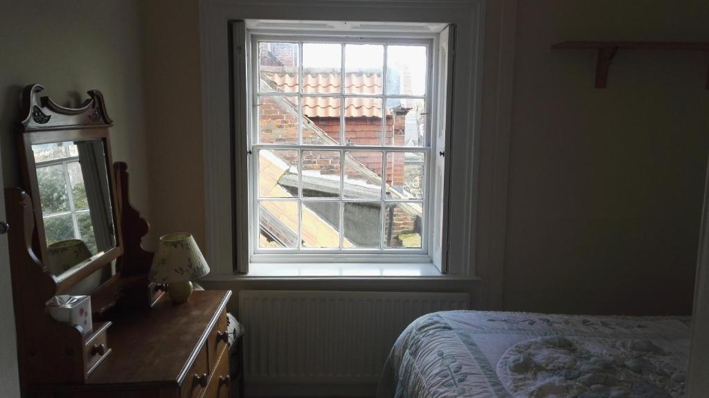 a bedroom with a window and a bed and a dresser at Teesdale Rooms in Whitby