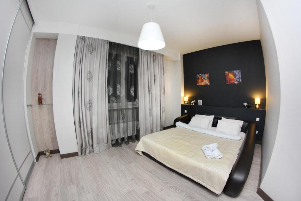 a bedroom with a large bed with a black wall at 310 Уютные дизайнерские апартаменты в отличном районе Идеально для командированных и туристов in Almaty