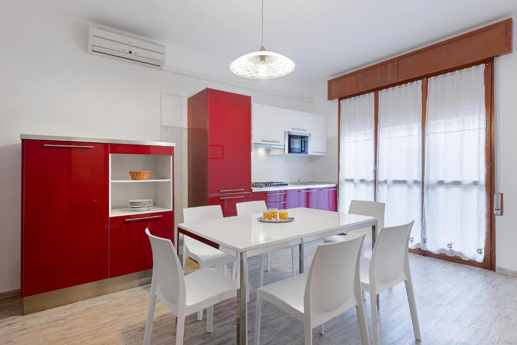 cocina con mesa blanca y sillas blancas en Residence Eur, en Sottomarina