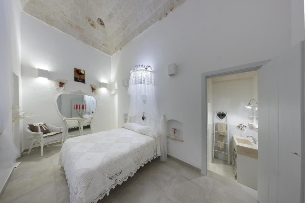 Habitación blanca con cama y lavabo en Maruska Residenze, en Fasano
