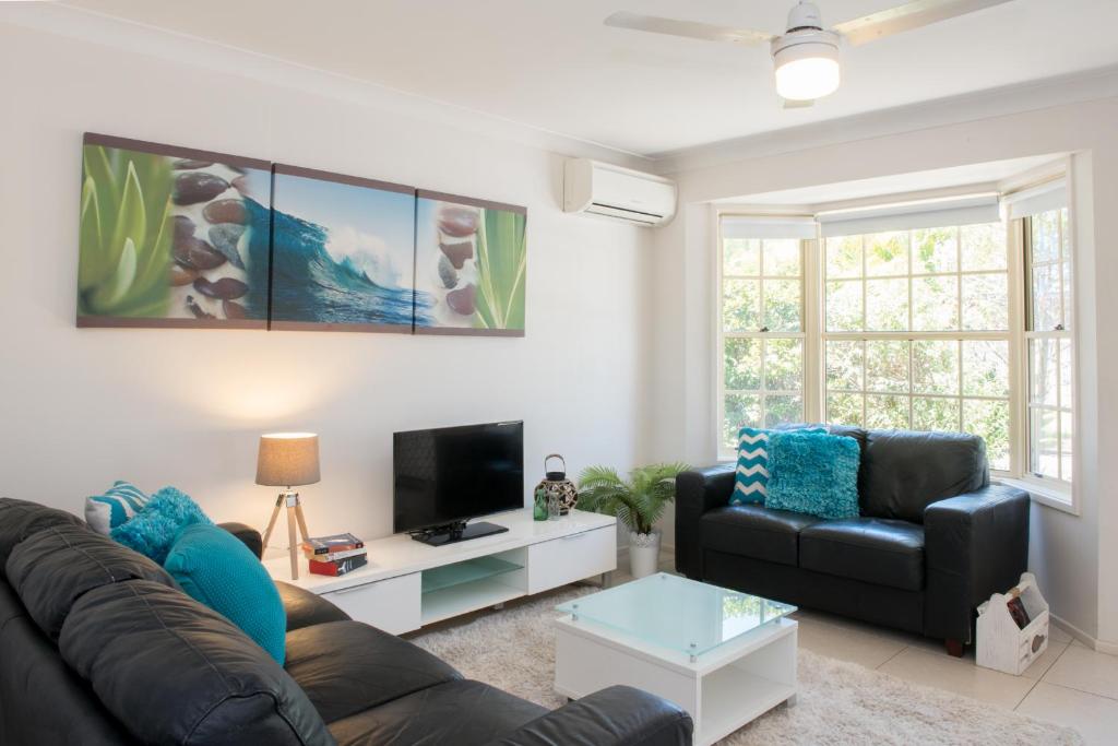 a living room with a couch and a tv at Gold Coast Theme Park Family Villa in Gold Coast