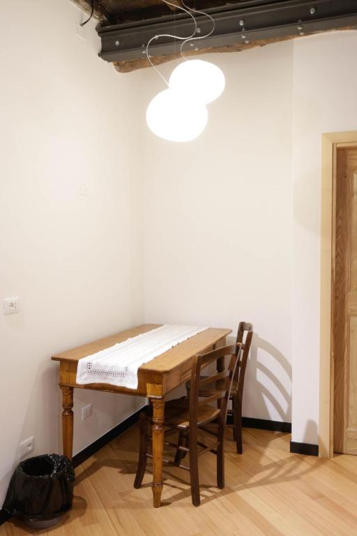 a table and chairs in a room with a white wall at Scorci Di Mare in Riomaggiore