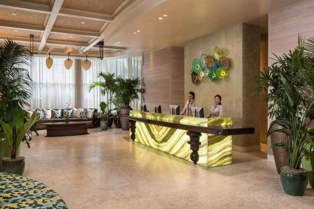 zwei Personen sitzen in einer Lobby mit Pflanzen in der Unterkunft The Palms Hotel &amp; Spa in Miami Beach
