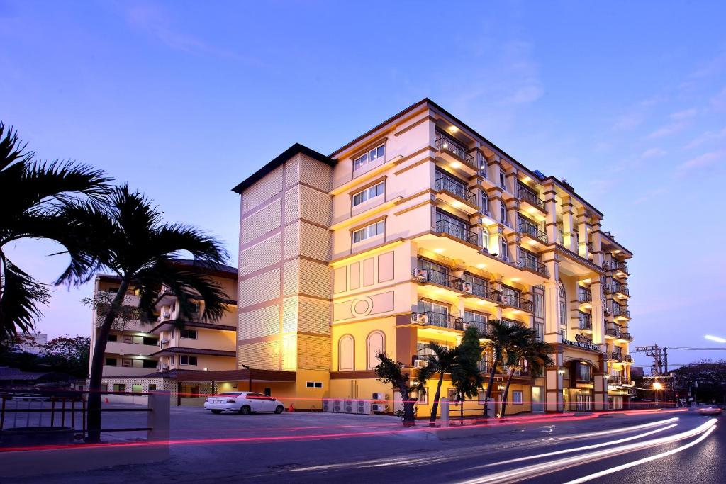 ein Gebäude mit einem davor geparkt in der Unterkunft Victoria Nimman Hotel in Chiang Mai