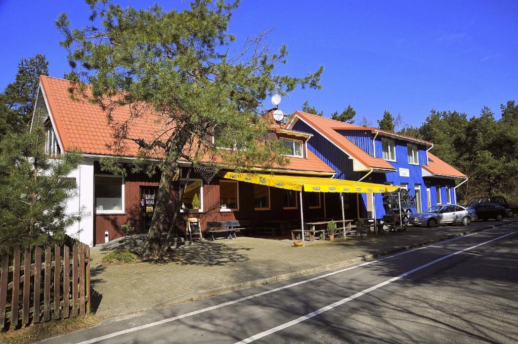 un edificio azul con toldo amarillo en una calle en Pakrantė en Klaipėda