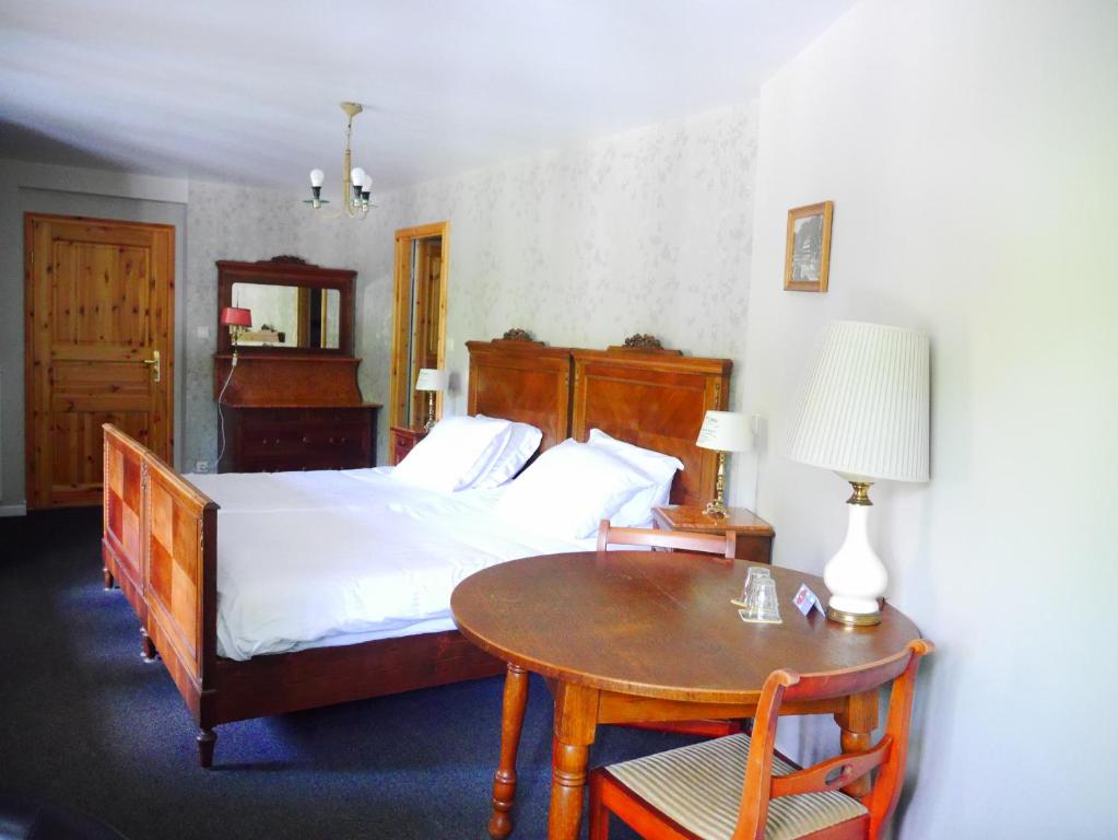 a bedroom with a bed and a table with a tableasonable at Hotel Dirbach Plage in Dirbach