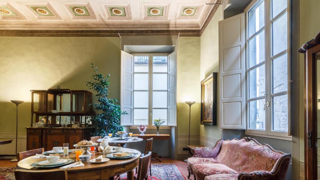 uma sala de jantar com uma mesa e uma cadeira em Dimora Storica Palazzo Puccini em Pistoia