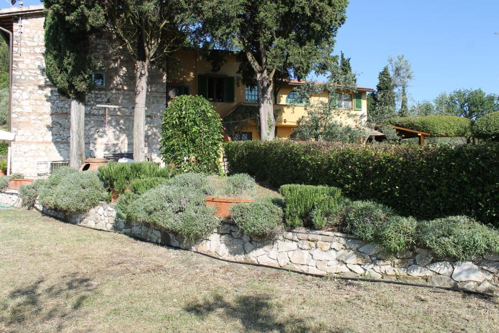 un jardin en face d'une maison avec des buissons dans l'établissement Piccolo Campagna, à Bagno a Ripoli