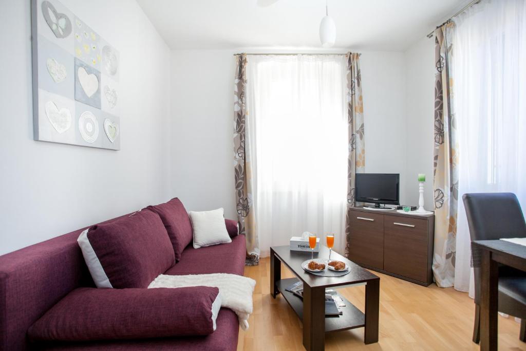 a living room with a purple couch and a table at Apartments Goda Center Of Split in Split