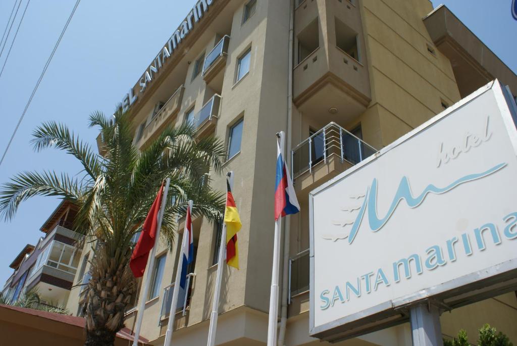 a hotel with flags in front of a building at Santa Marina Hotel in Antalya