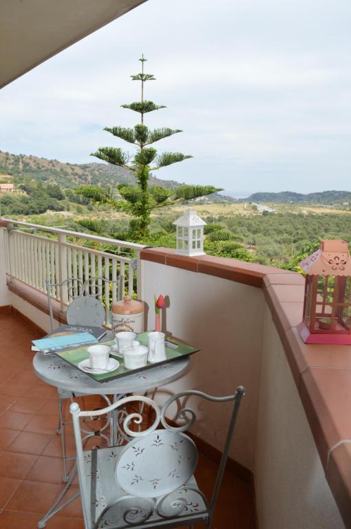 un balcón con mesa, sillas y un pino en La Casa di Giulia, en Forza dʼAgro