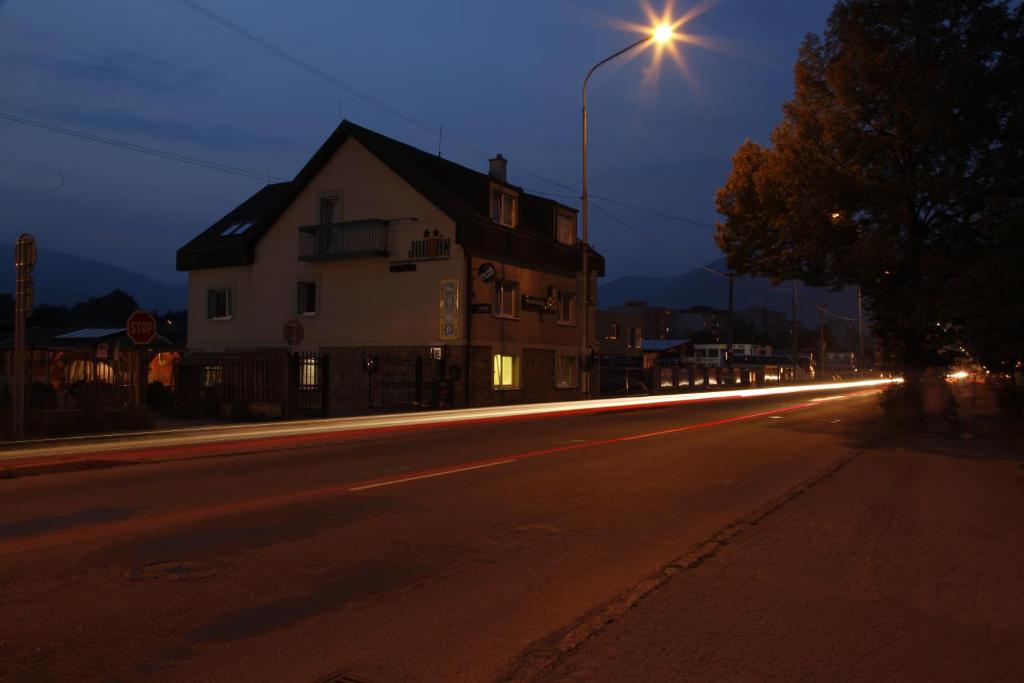 a street at night with a house and a street light at Penzion Jordan in Martin