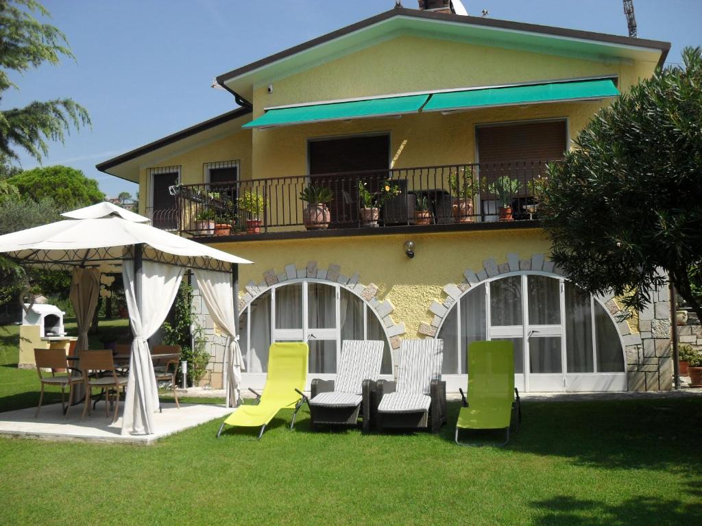 a house with chairs and a table and an umbrella at Casa Romantica in Bardolino