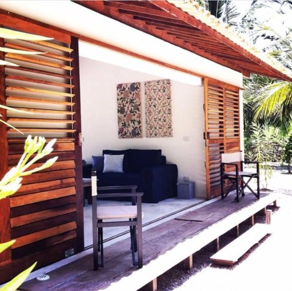 a patio with a couch and a table and chairs at Abaetetuba Pousada in São Miguel dos Milagres