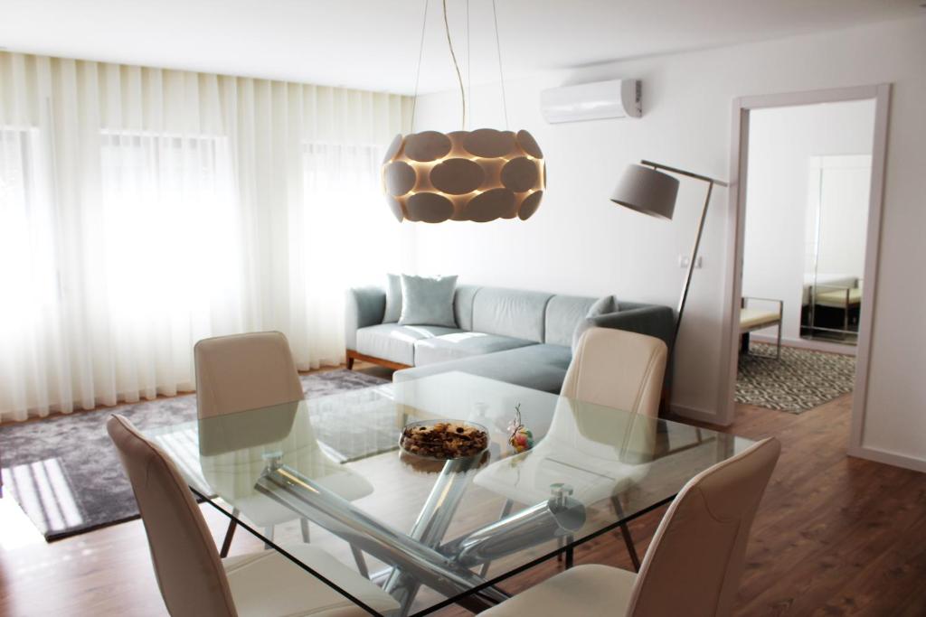 a living room with a glass table and a couch at Bracara Guest House "Bom Jesus" in Braga