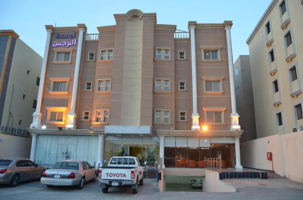 a hotel with cars parked in front of it at Al Narjes Hotel Suites Al Khobar in Al Khobar