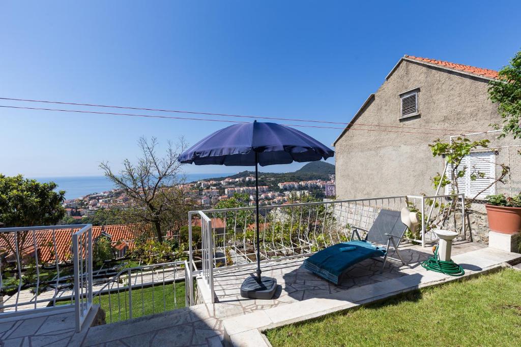 een patio met een parasol, een stoel en een tafel bij Apartment Milic in Dubrovnik