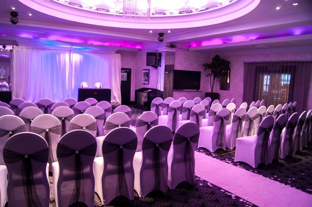a room with rows of chairs in a room with purple lighting at Cumberland Hotel - OCEANA COLLECTION in Bournemouth