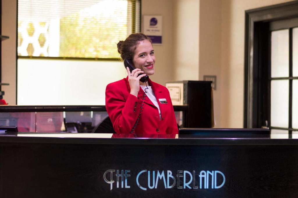 a woman is talking on a cell phone at Cumberland Hotel - OCEANA COLLECTION in Bournemouth