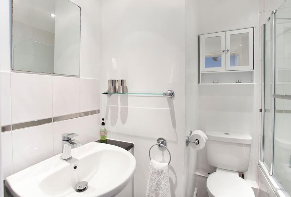a white bathroom with a sink and a toilet at Victoria Bar Apartments Within the City Walls Free Parking in York