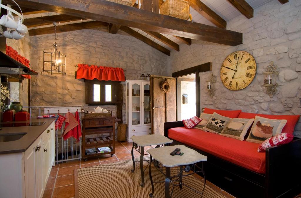 - un salon avec un canapé et un réveil sur le mur dans l'établissement Casa Concejos, à San Román de Cameros