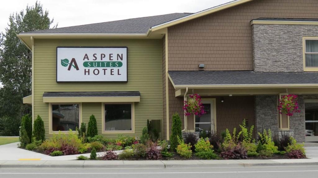 un edificio verde con un cartel para un hotel con spa en Aspen Suites Hotel Haines en Haines
