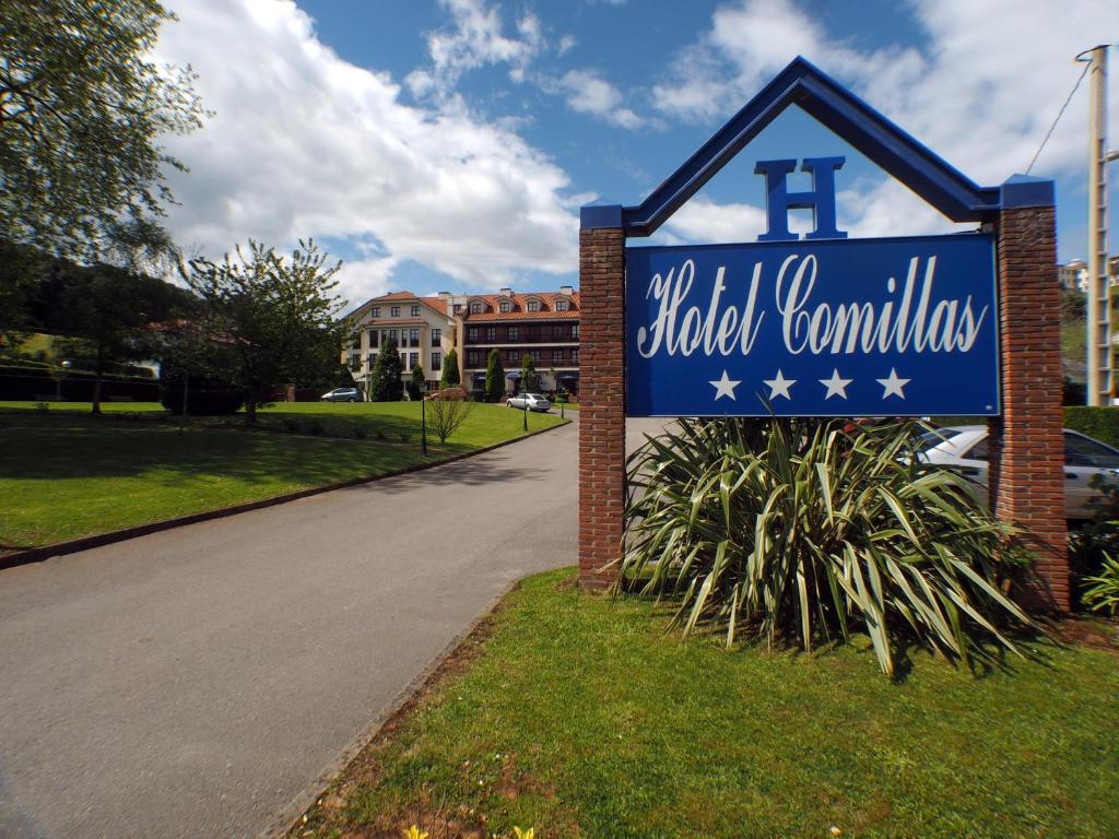 una señal azul para una escuela con una calle en Hotel Comillas, en Comillas