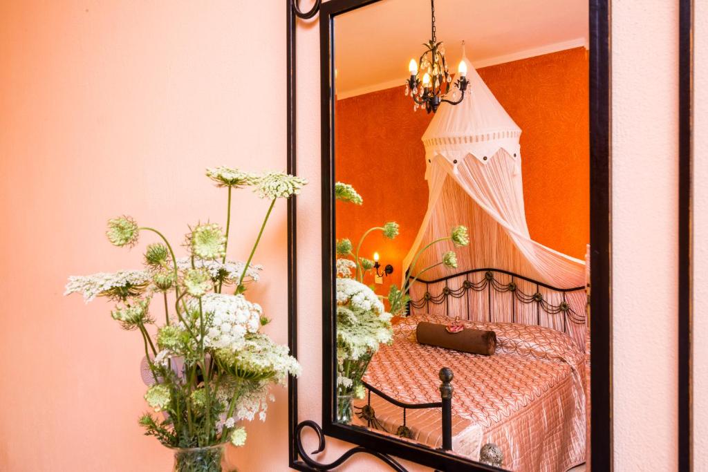 espejo que refleja un dormitorio con cama y flores en Villa Irida, en Potos