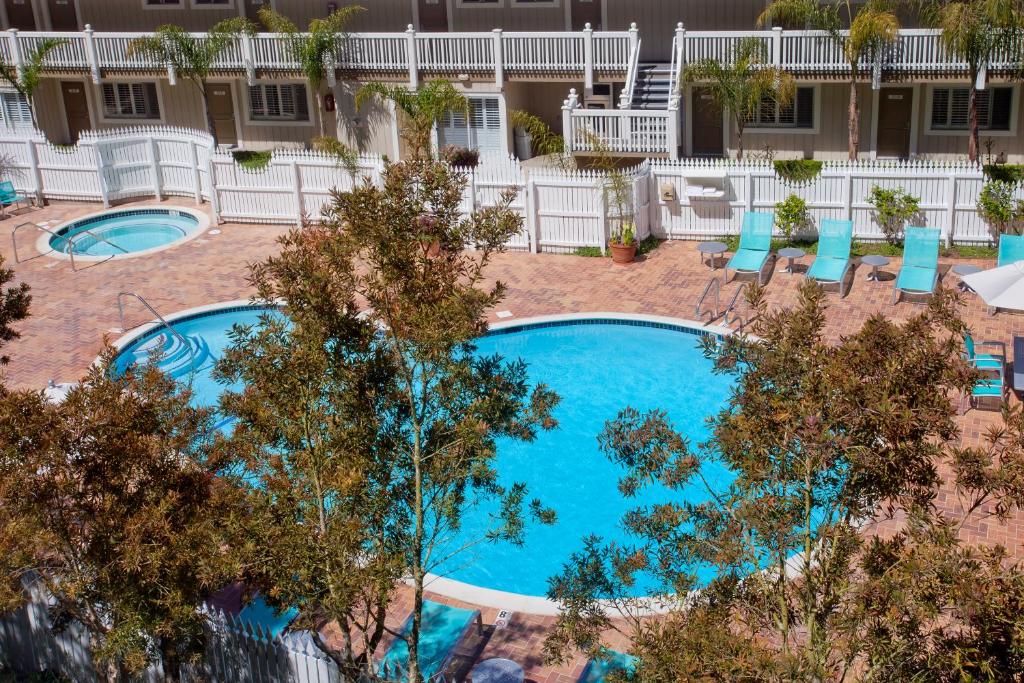 a large swimming pool with trees and lawn chairs at Inn at Morro Bay in Morro Bay